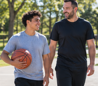 A learner and instructor walking together outdoors with a basketball